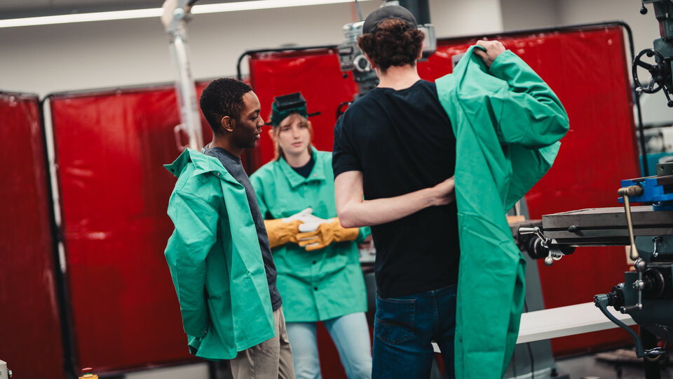 Students gear up in PPE to practise welding.
