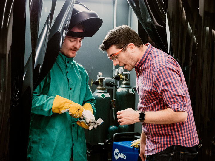 A student has faculty inspect a weld.